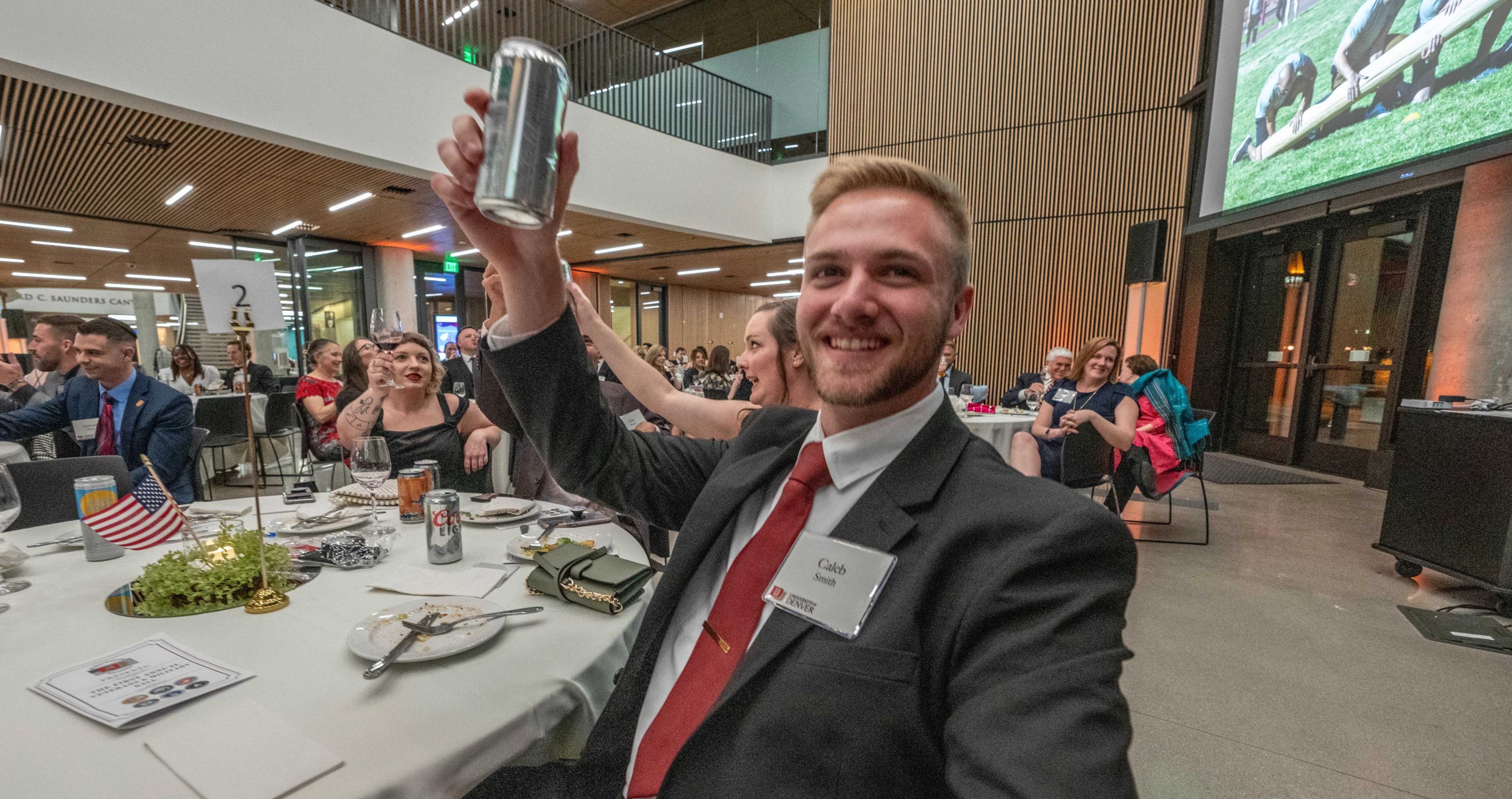 Senior Caleb Smith, president of the Student Veterans Association, raises a glass at DU's 2024 Veterans Ball