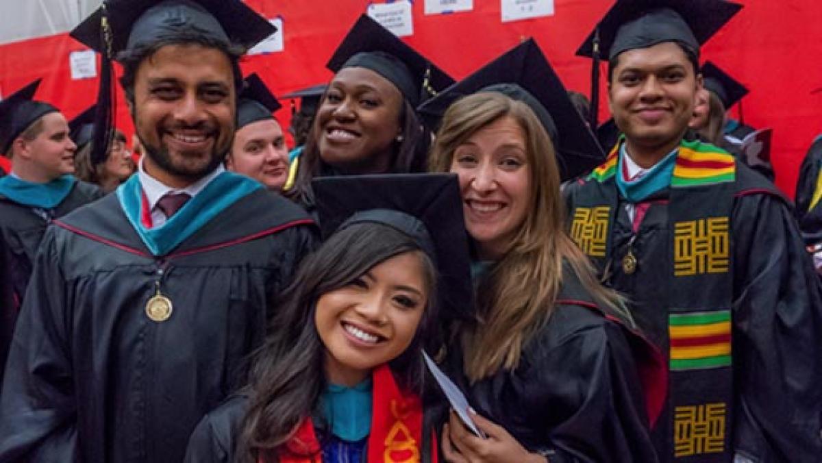 DU graduates posing together at commencement