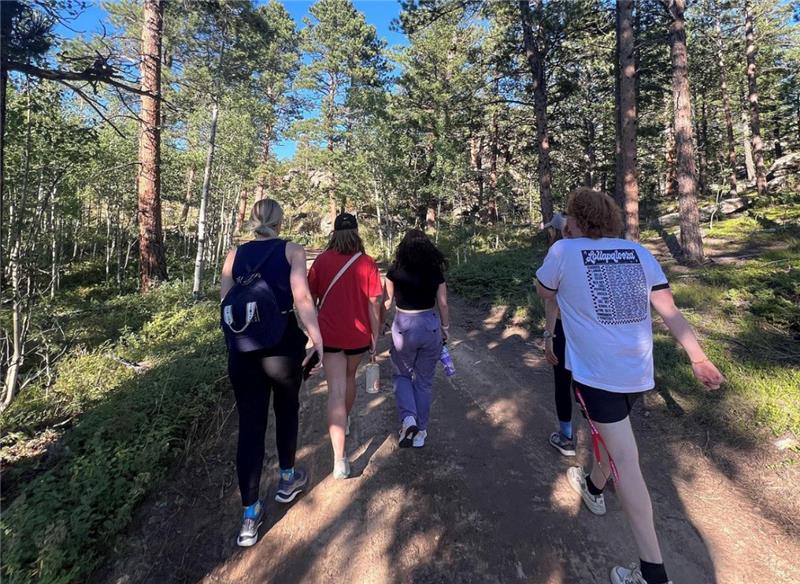 group of five shot from behind, walking through woods