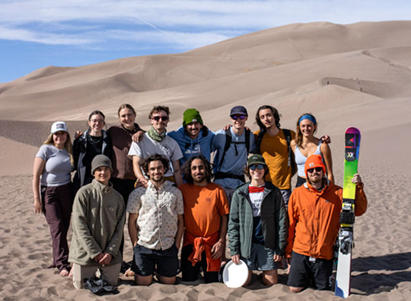 Clum Mountain Sports group posing by sand dunes
