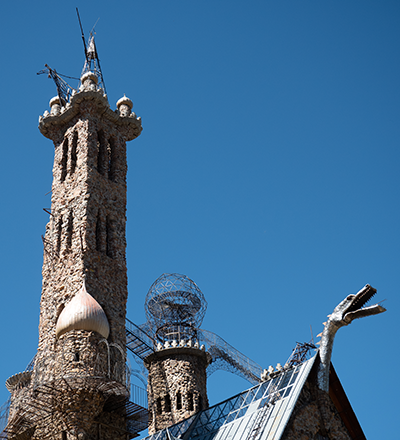 A tower and roof-mounted dragon at Bishop Castle with blue sky in the background