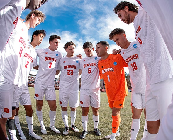 The DU men's soccer team huddles before the match against UMass.