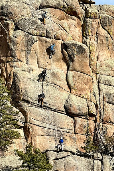 Climbers scaling a vertical via ferrata section