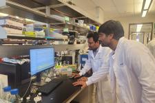 Sunil Kumar and another researcher in white lab coats looking at a screen