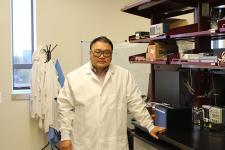 Dali Sun stands by a table in his lab