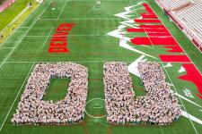 First-year students form a D and U at Peter Barton Lacrosse Stadium for their class of 2028 photo.