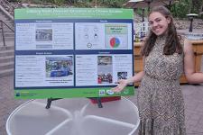 Sidney Barbier stands next to her poster presentation.