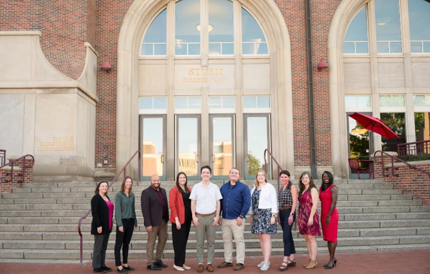 staff members from the office of academic advising. standing in front of an academic building. team of 11 advisors.