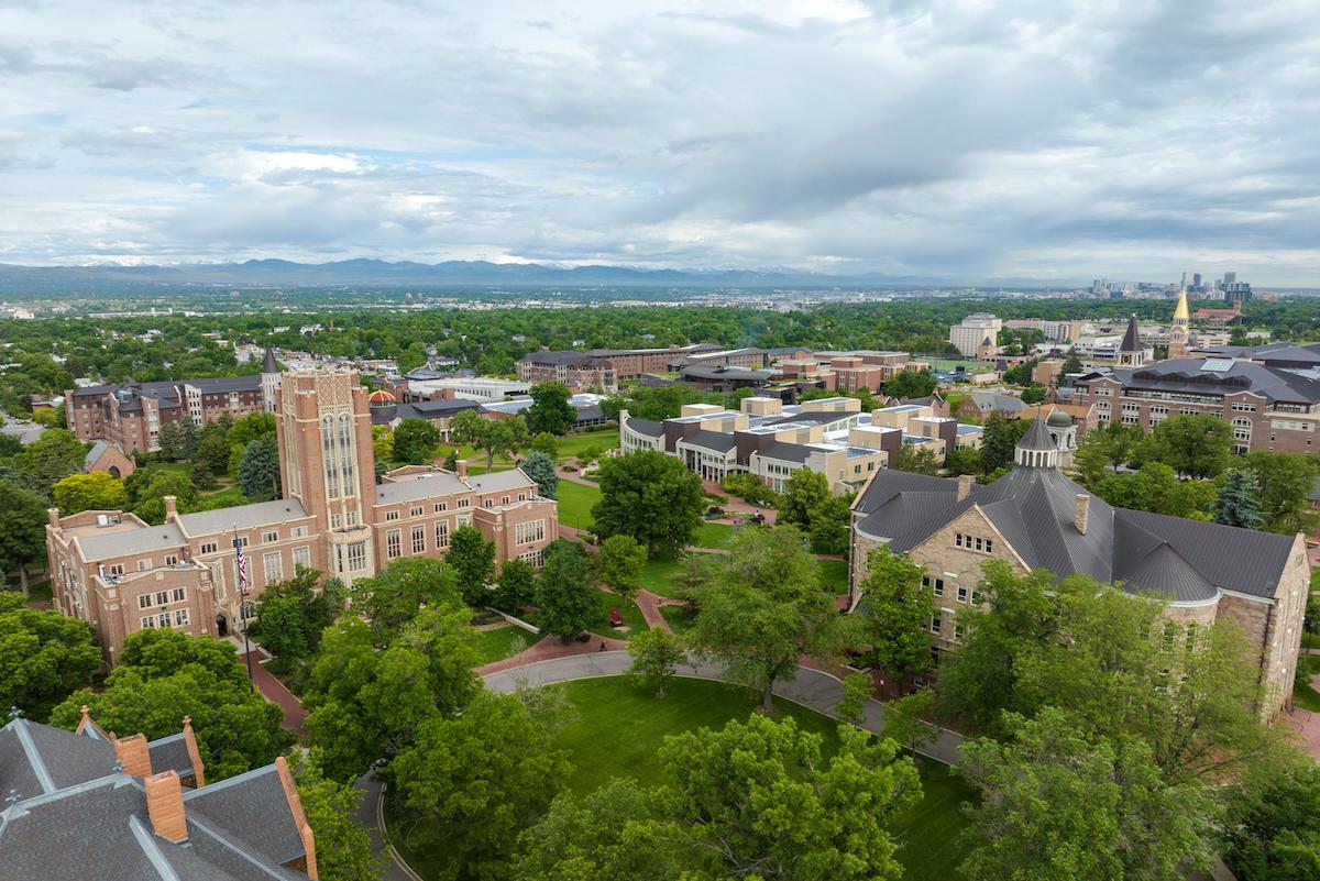 Aerial view of DU campus with the Rocky Mountains and Denver skyline in the background