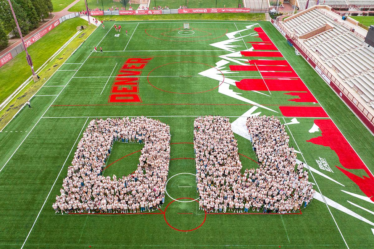 First-year students form a D and U at Peter Barton Lacrosse Stadium for their class of 2028 photo.