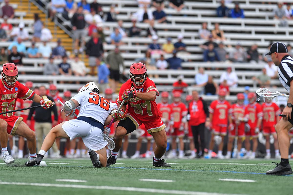 A DU lacrosse player in a face off with a Syracuse lacrosse player.