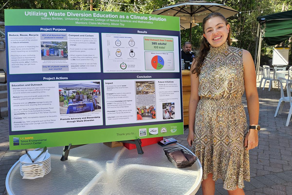 Sidney Barbier stands next to her poster presentation.