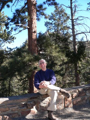 Tim Leddy in front of a mountain and pine trees. 