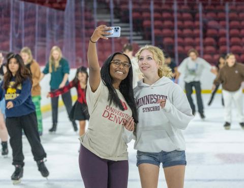 2 DU students talk a selfie on the ice. 