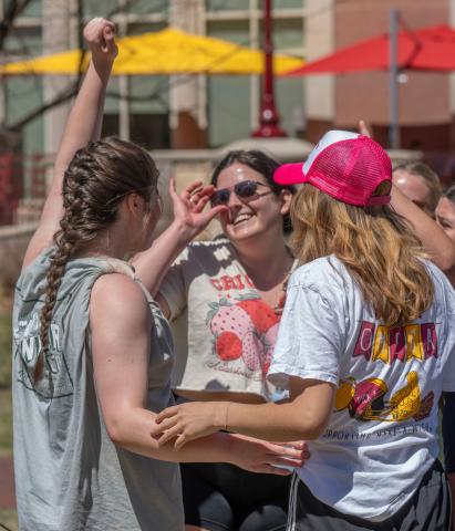 Three University of Denver students celebrate during a game of moonball. 