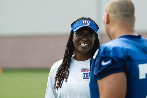 Lani Lawrence talks to a football player. 