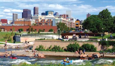 Kayakers in Confluence Park in Denver, Colorado with the downtown skyline in the background. 