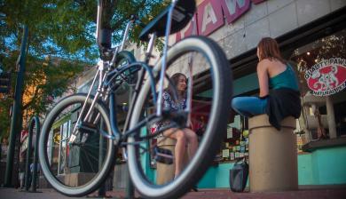 A bicycle is parked on the sidewalk in south broadway 