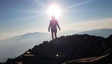 Person standing in the sun on top of Quandary Peak