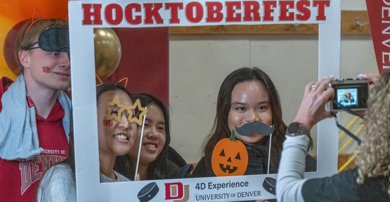 Students pose for a photo with props for Hocktoberfest.