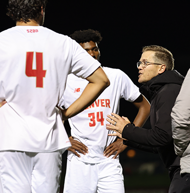 Head coach Jamie Franks speaks to his athletes during a game.