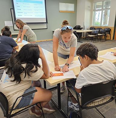 Sidney Barbier helps students on an exercise during a summer camp.