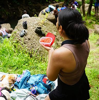 Tenzin stands while eating fruit in Grenada.