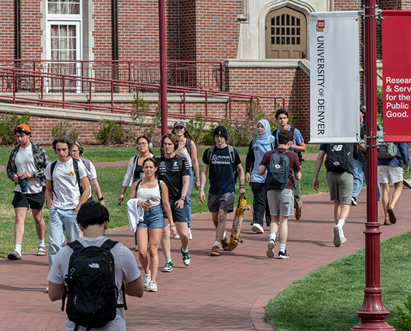 Students walking on a brick path through DU's campus