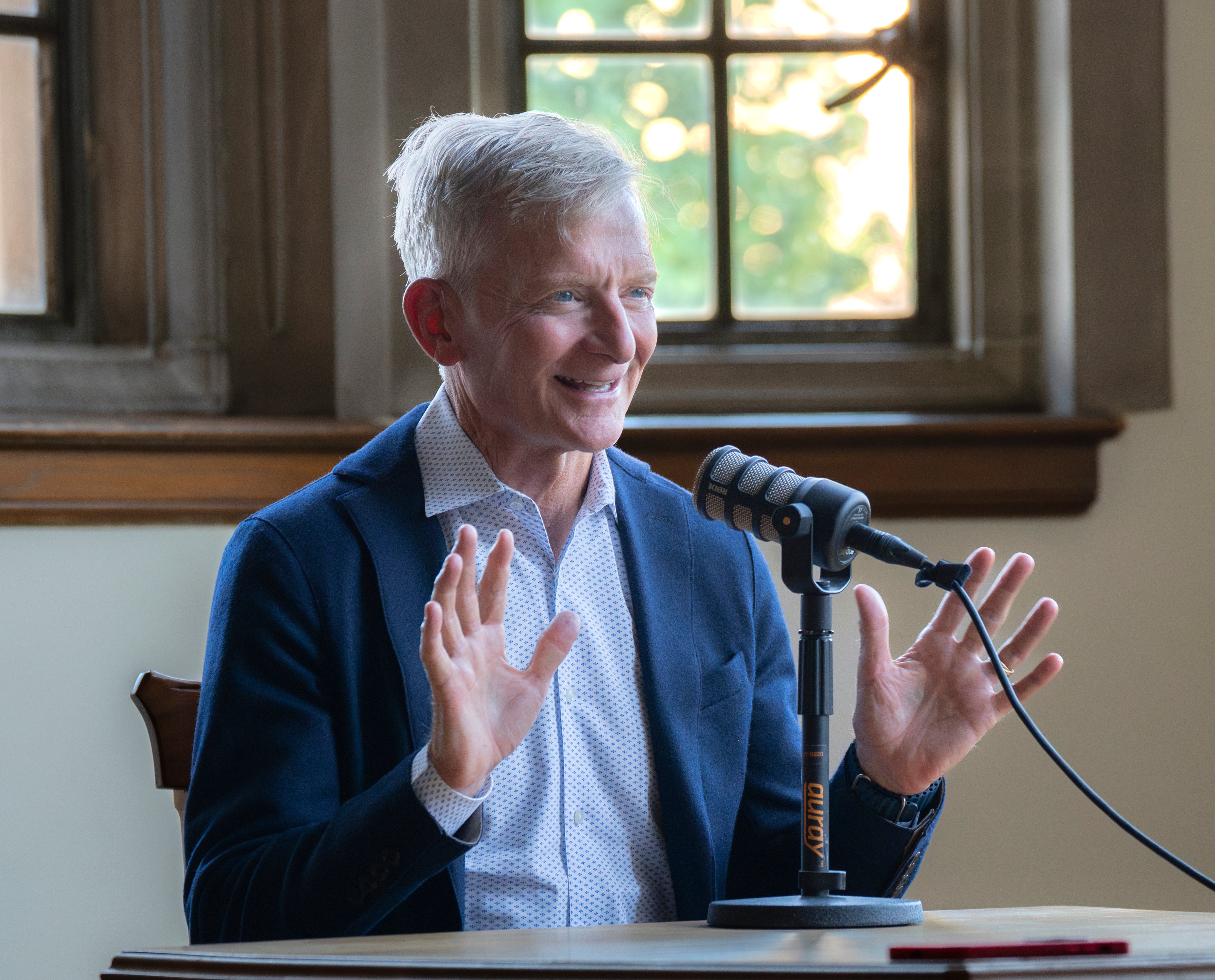 Chancellor Haefner speaks in front of a podcast microphone.